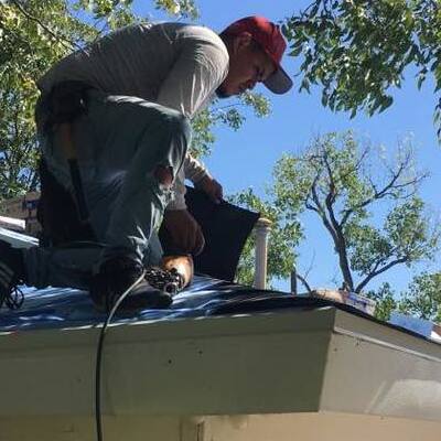 A Roofer Repairs a Shingle Roof.